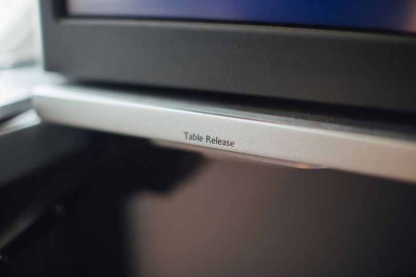 The tray table extends from under the video screen.